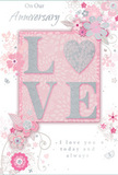 In this image, the anniversary card appears as a gentle tribute to enduring romance, its colours a soothing blend of pastel pinks, soft greys, and silvery whites that echo the quiet charm of East Dulwich streets in early evening. The central focus is the word LOVE, crafted in slightly raised, glitter-dusted letters that glimmer modestly when light passes over them. Instead of a standard O, a shimmering heart, filled with fine silver glitter, takes its place, creating a tactile and visual highlight that symbolises the warmth at the centre of a relationship. Around this main motif, delicate flowers in blush, mauve, and pale ivory open their petals along slender stems, painted with an almost watercolour softness that suggests both care and lightness. Gentle curls of foliage, tiny petals, and subtle butterflies scatter through the design, giving a sense of movement like a soft breeze moving through a spring garden near Peckham Rye. The background remains a calm, warm blush tone, helping the glittering central word and the floral details stand out clearly. Phrases such as On Our Anniversary and I love you today and always are written in an elegant, flowing script, easy to read yet full of feeling, as though spoken quietly over a glass of wine at home. The whole composition feels intimate and timeless, like a carefully chosen bouquet delivered from East Dulwich Florist-soft-spoken but deeply meaningful, and perfect for marking a shared journey of love.